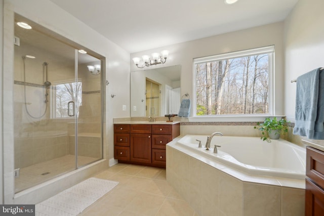 full bathroom featuring a garden tub, a healthy amount of sunlight, a stall shower, and vanity