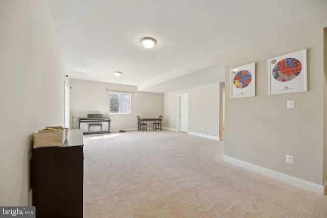 sitting room featuring baseboards and carpet