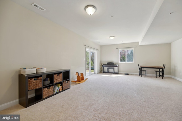 living area featuring visible vents, baseboards, and carpet