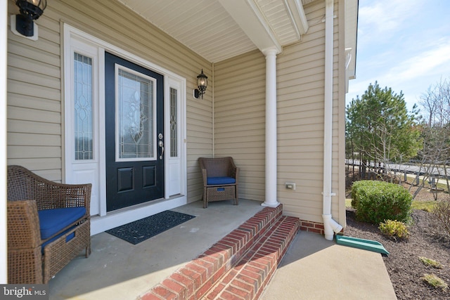 doorway to property with a porch and fence