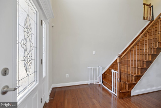 entryway featuring stairway, baseboards, and wood finished floors