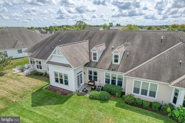 back of property featuring central AC and a lawn