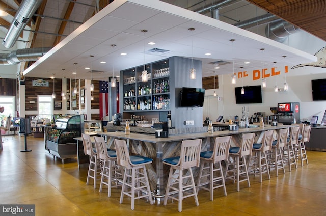 bar with pendant lighting and a towering ceiling