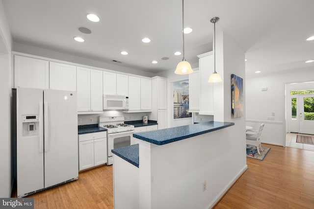 kitchen with white appliances, white cabinetry, hanging light fixtures, light hardwood / wood-style floors, and kitchen peninsula