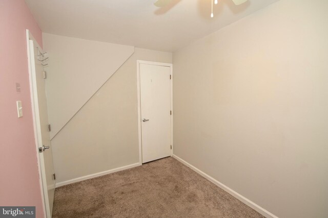 empty room featuring ceiling fan, carpet flooring, and baseboards