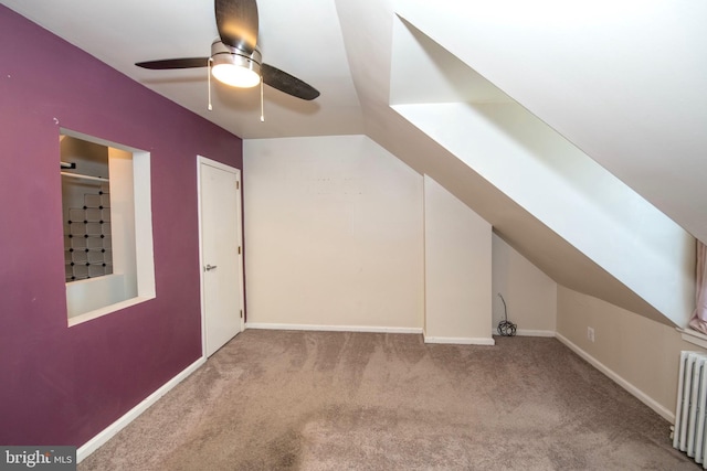 additional living space featuring carpet floors, lofted ceiling, radiator heating unit, ceiling fan, and baseboards