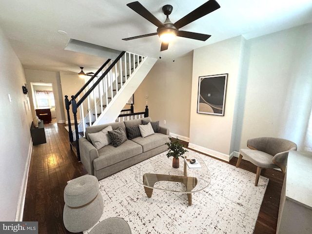 living room with hardwood / wood-style flooring, ceiling fan, baseboards, and stairs