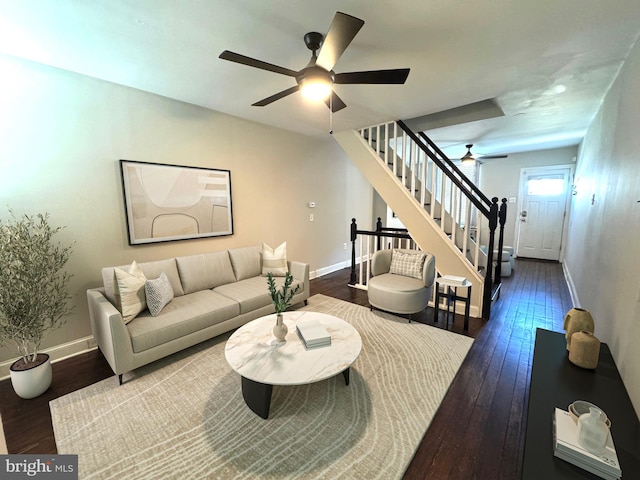 living room with stairway, wood-type flooring, and baseboards