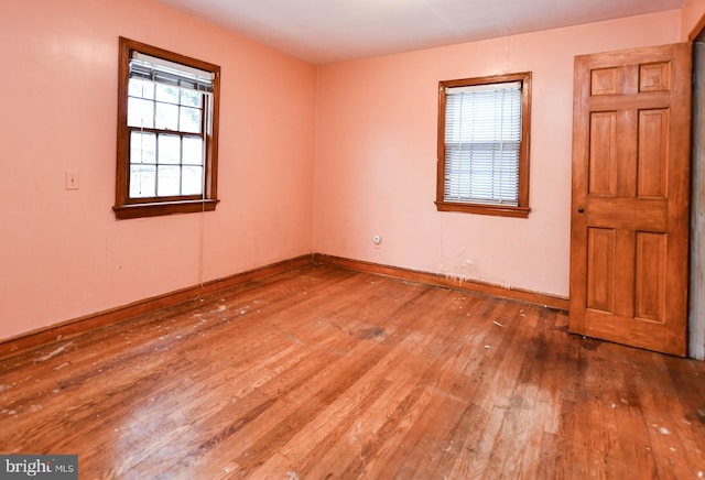 unfurnished room featuring a healthy amount of sunlight and hardwood / wood-style floors