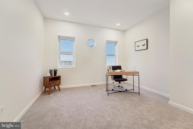 home office featuring plenty of natural light and light colored carpet