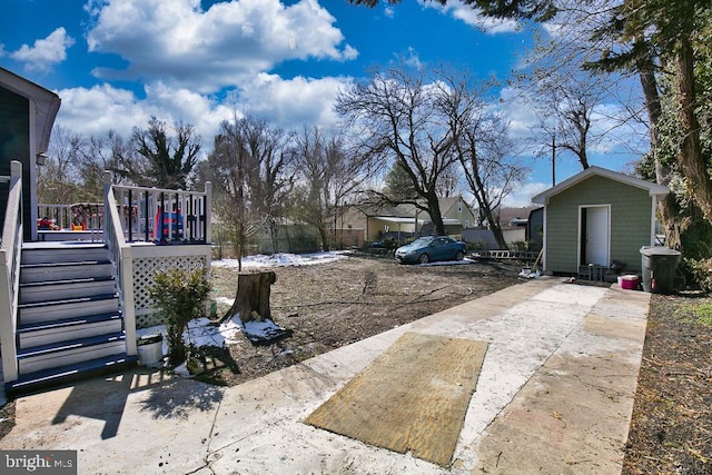 view of yard featuring a wooden deck and an outbuilding