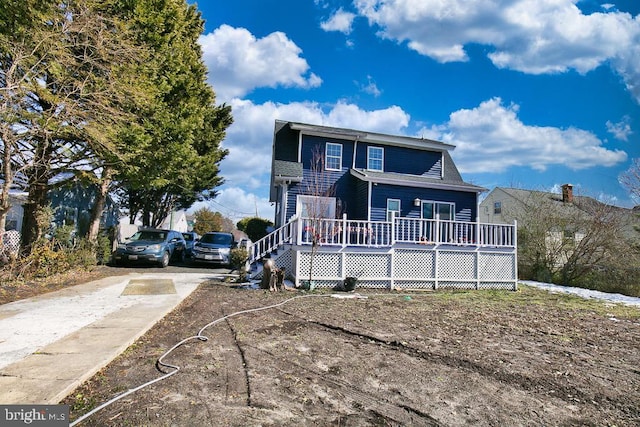 view of front of home with driveway and a wooden deck