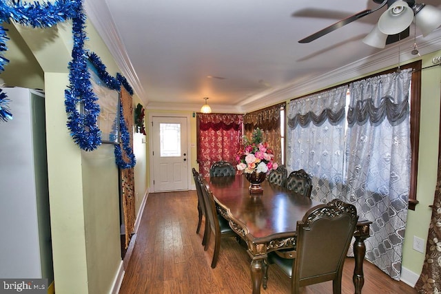 dining room featuring a ceiling fan, baseboards, ornamental molding, and wood finished floors