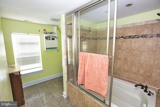 full bathroom featuring visible vents, tiled shower / bath, baseboards, and vanity