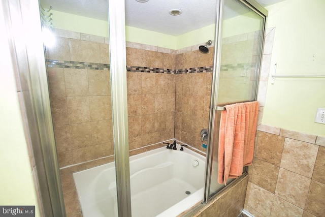 bathroom with tiled shower / bath combo and tile walls