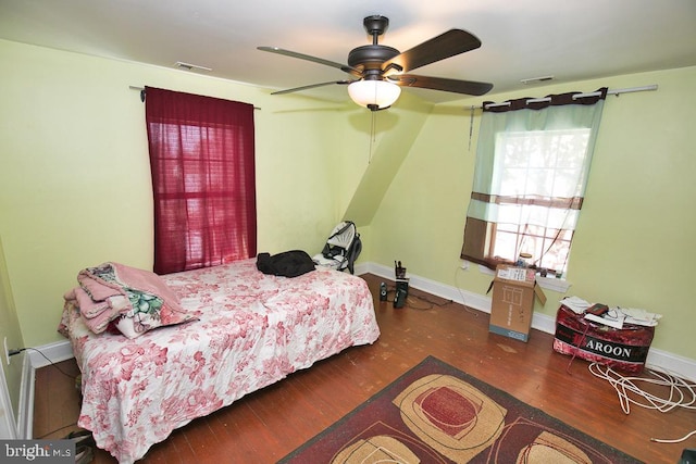 bedroom with visible vents, baseboards, and wood finished floors