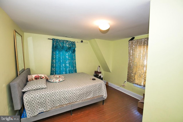 bedroom with visible vents, hardwood / wood-style flooring, and baseboards