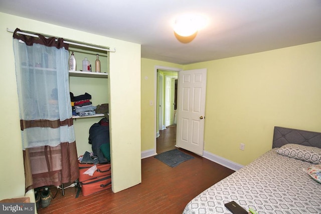 bedroom featuring a closet, baseboards, and wood finished floors