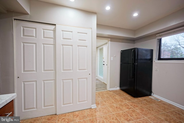 kitchen with black refrigerator and light tile patterned flooring