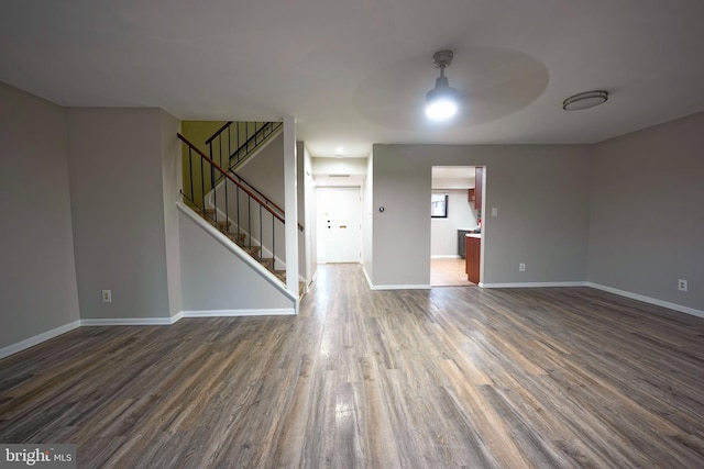 unfurnished living room with dark wood-type flooring and ceiling fan