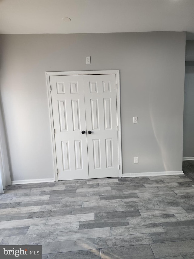 unfurnished bedroom featuring hardwood / wood-style floors and a closet