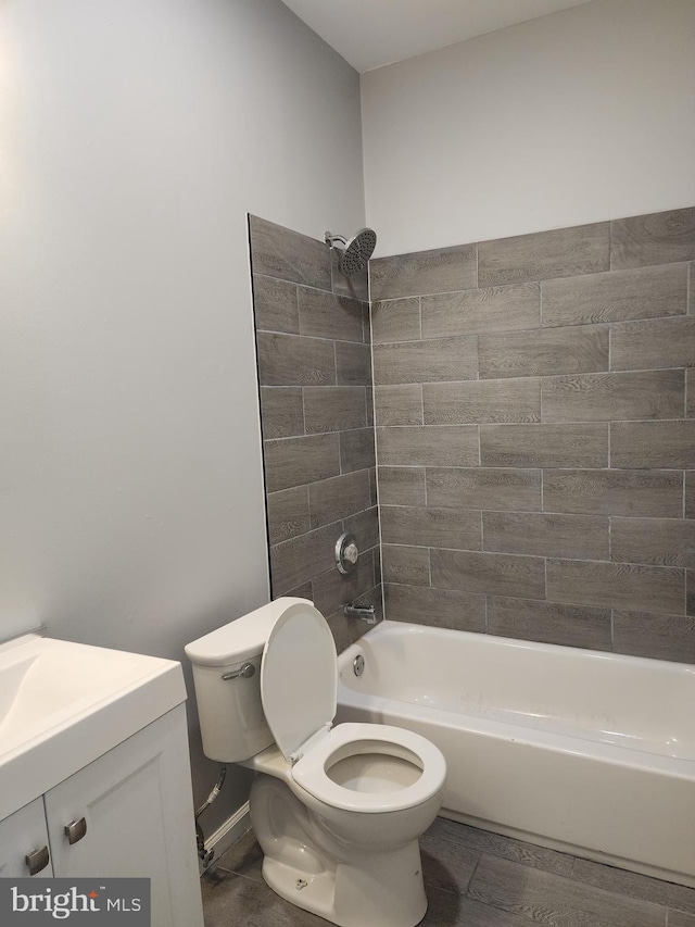 full bathroom with tiled shower / bath, vanity, and toilet