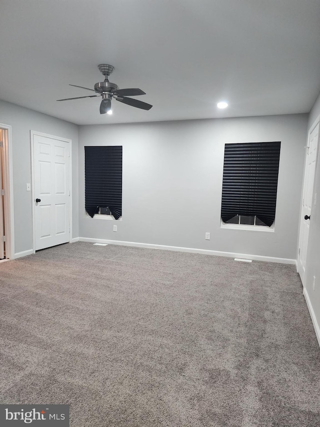 carpeted spare room featuring ceiling fan