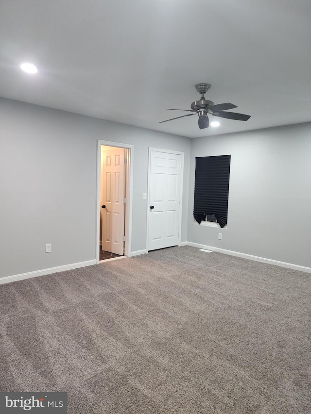 carpeted spare room featuring ceiling fan