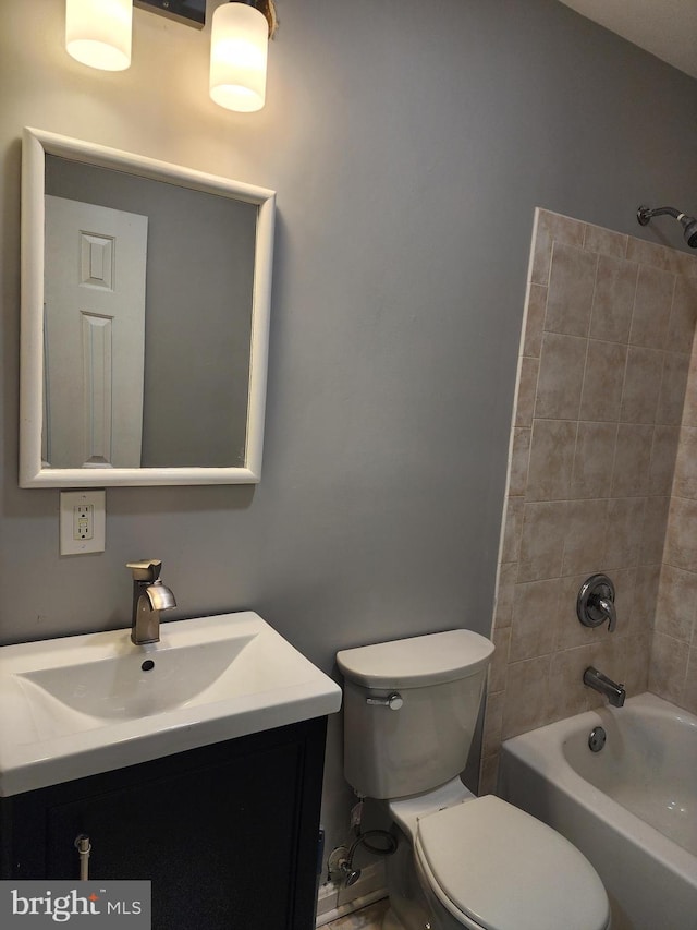 full bathroom with tiled shower / bath, vanity, and toilet