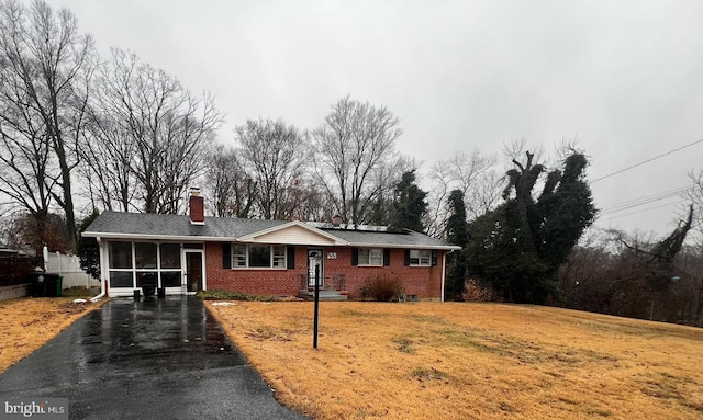 ranch-style house with a front lawn and a sunroom