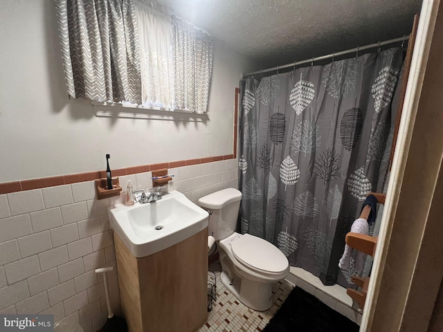 bathroom featuring tile walls, tile patterned flooring, vanity, a textured ceiling, and toilet