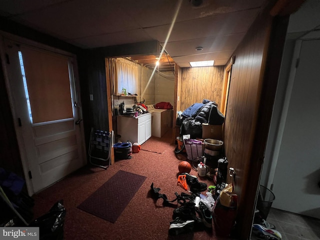 basement featuring washing machine and dryer, carpet floors, a drop ceiling, and wood walls