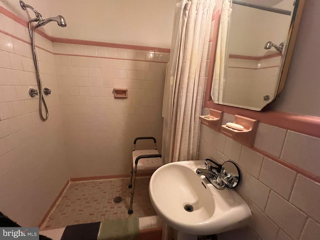 bathroom with tile walls, sink, and curtained shower