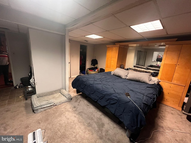 bedroom with a paneled ceiling and carpet flooring