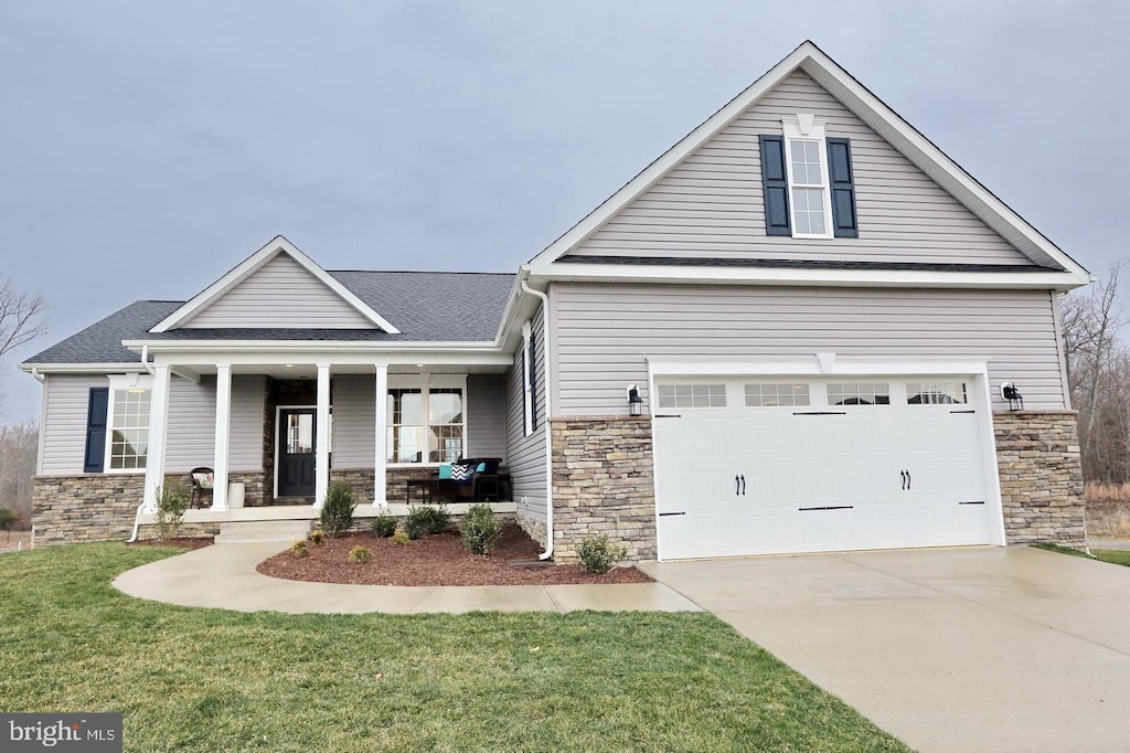 view of front facade featuring a porch, a garage, and a front yard