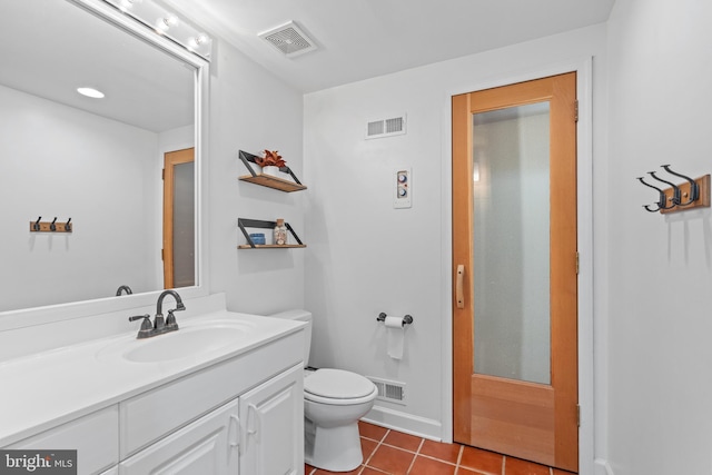 bathroom with tile patterned flooring, vanity, and toilet