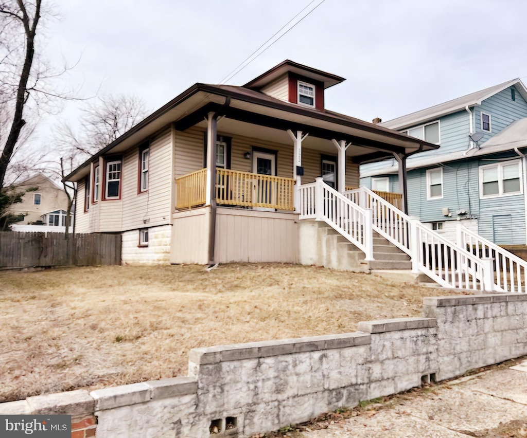 bungalow with a porch, fence, and stairs