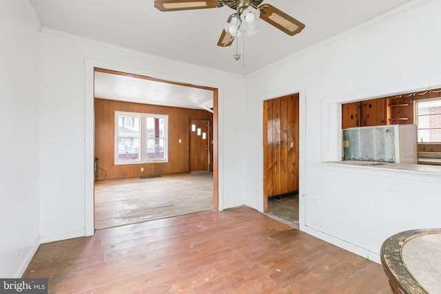 interior space with hardwood / wood-style flooring, crown molding, and wooden walls