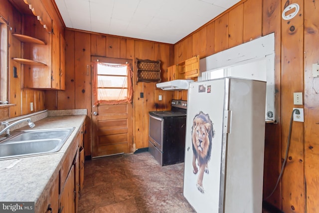 kitchen featuring sink, electric range, wood walls, and white refrigerator