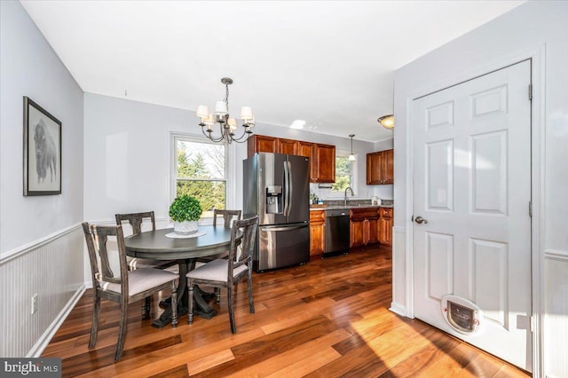 dining area featuring sink, dark hardwood / wood-style floors, a wealth of natural light, and an inviting chandelier