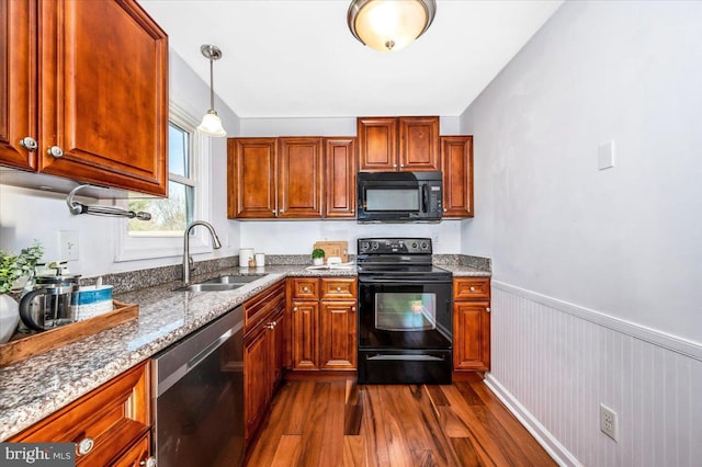 kitchen featuring stone countertops, dark hardwood / wood-style floors, decorative light fixtures, sink, and black appliances