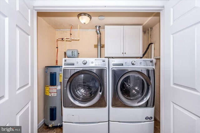 laundry room featuring water heater, cabinets, and washer and dryer