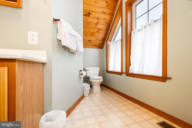 bathroom with wood ceiling, plenty of natural light, toilet, and vaulted ceiling