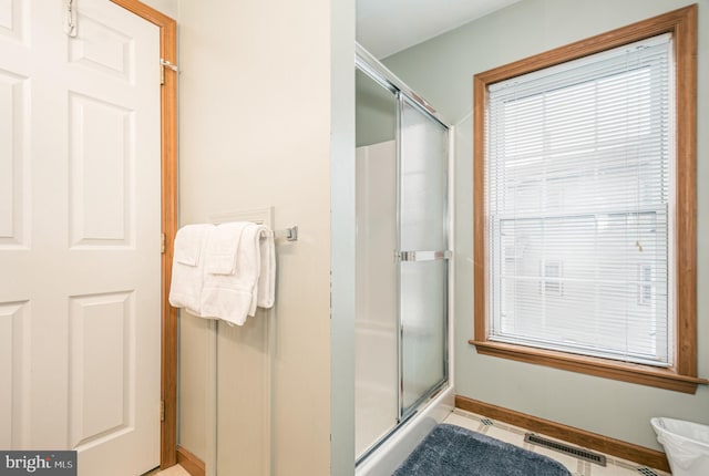 bathroom featuring a shower with door and tile patterned flooring