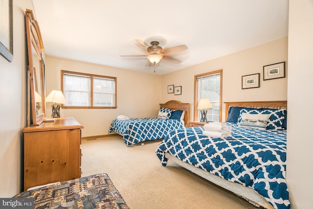 bedroom featuring ceiling fan, carpet floors, and multiple windows