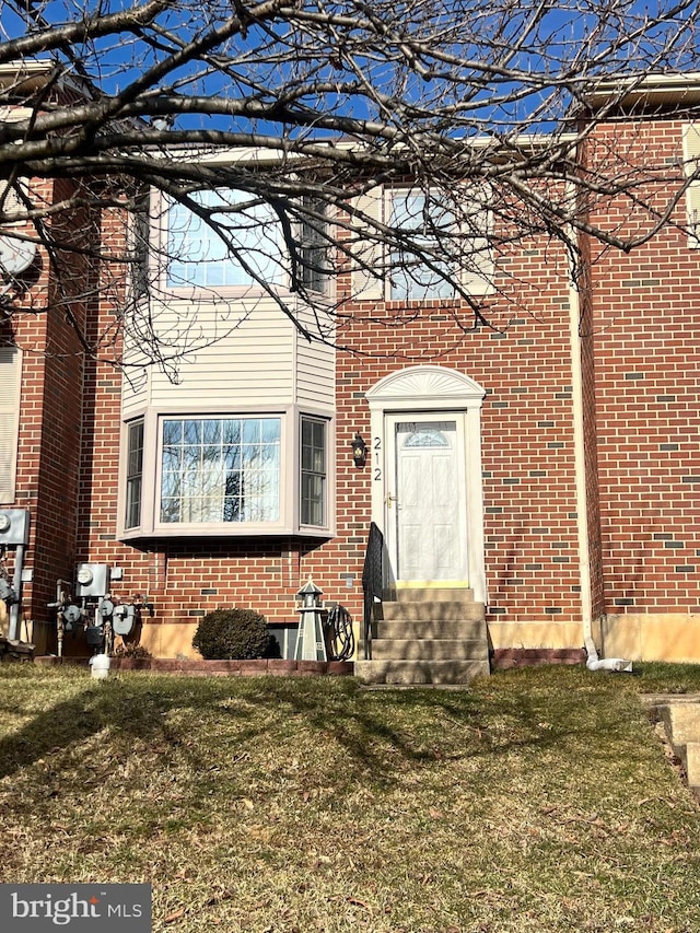 view of exterior entry with a lawn