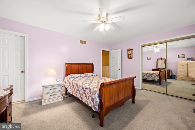 bedroom featuring light colored carpet, ceiling fan, and a closet