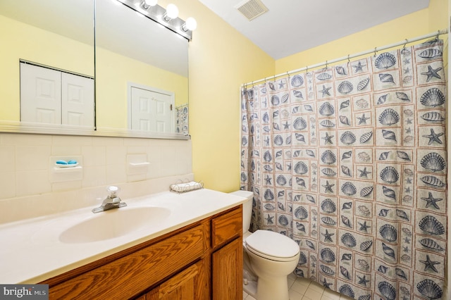 bathroom featuring a shower with shower curtain, vanity, tasteful backsplash, tile patterned floors, and toilet