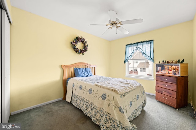 bedroom with a closet, ceiling fan, and dark colored carpet