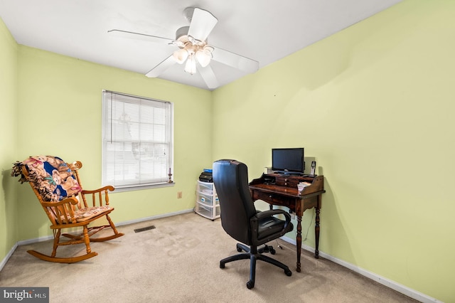 carpeted office space featuring ceiling fan